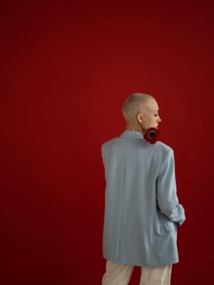 Faceless stylish woman with flower in studio