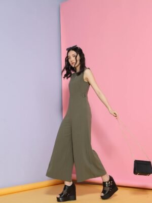 Full body of slender young female in trendy gray outfit looking at camera in corner of pink and blue walls