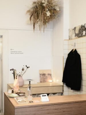 Interior of contemporary light clothes store or atelier studio with dry decorative plants on wooden counters